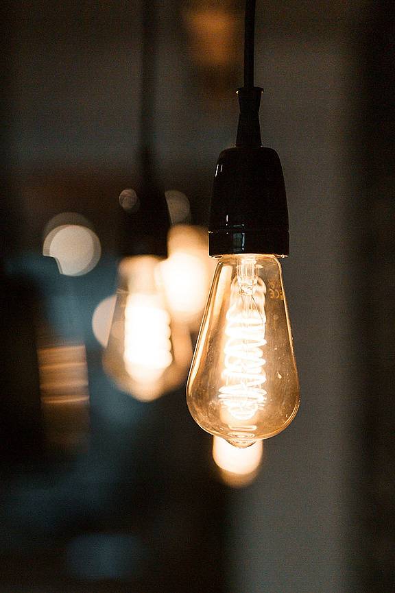 Glühbirne leuchtet vor dunklem Hintergrund