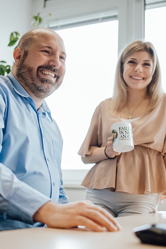 Mann und Frau an einem Schreibtisch im Gespräch