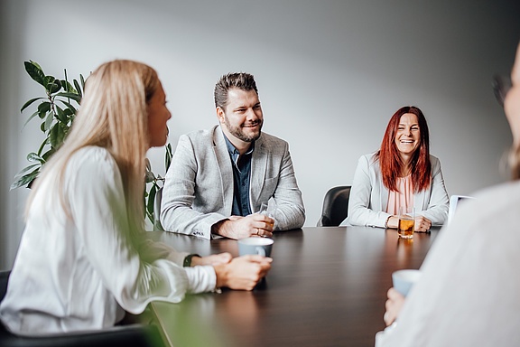 Team an einem Konferenztisch sitzend im Gespräch